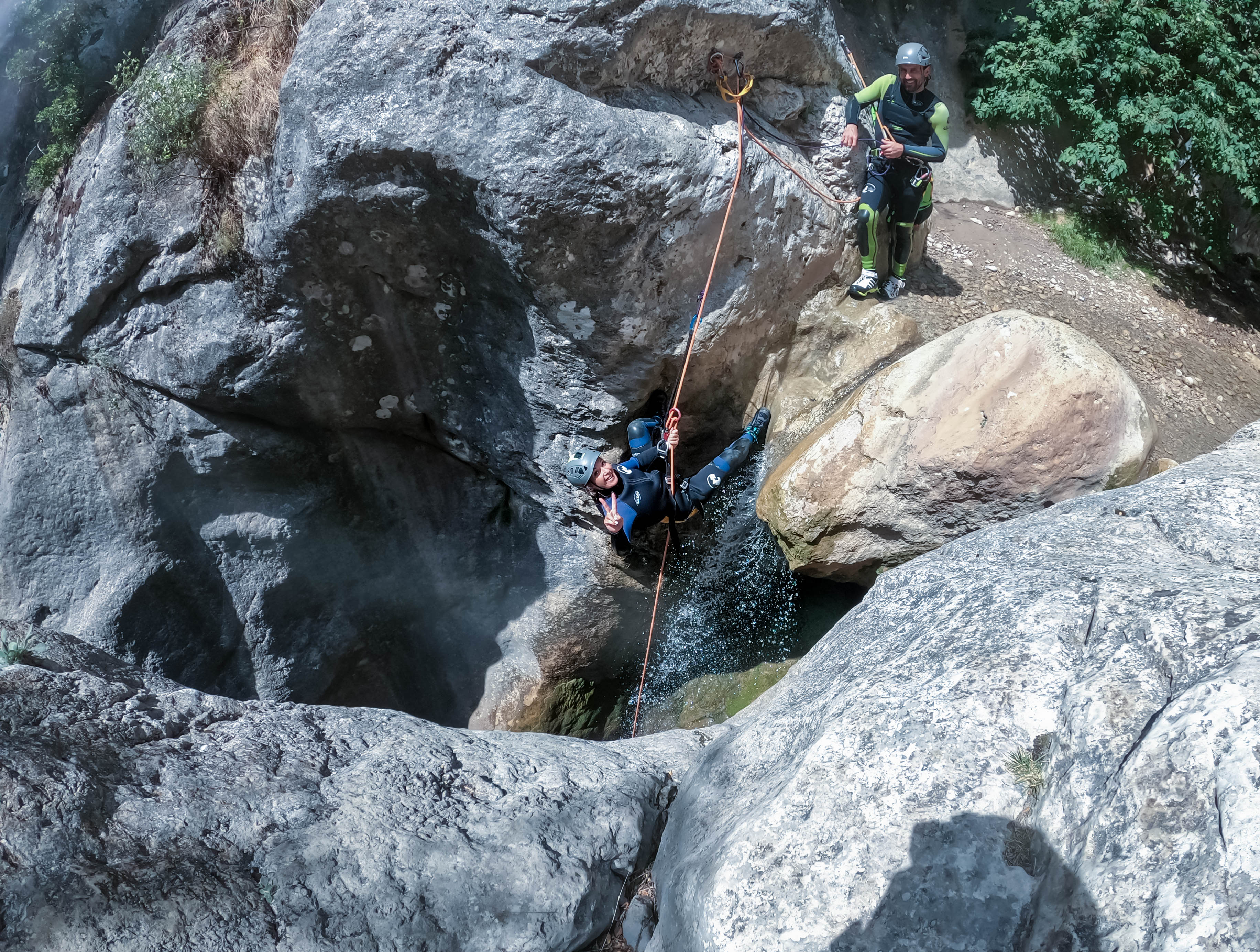 Barranquismo en el Pallars Jussà: participante realizando un rápel en un barranco de roca mientras el guía asegura el descenso en un cañón del Prepirineo de Lleida.