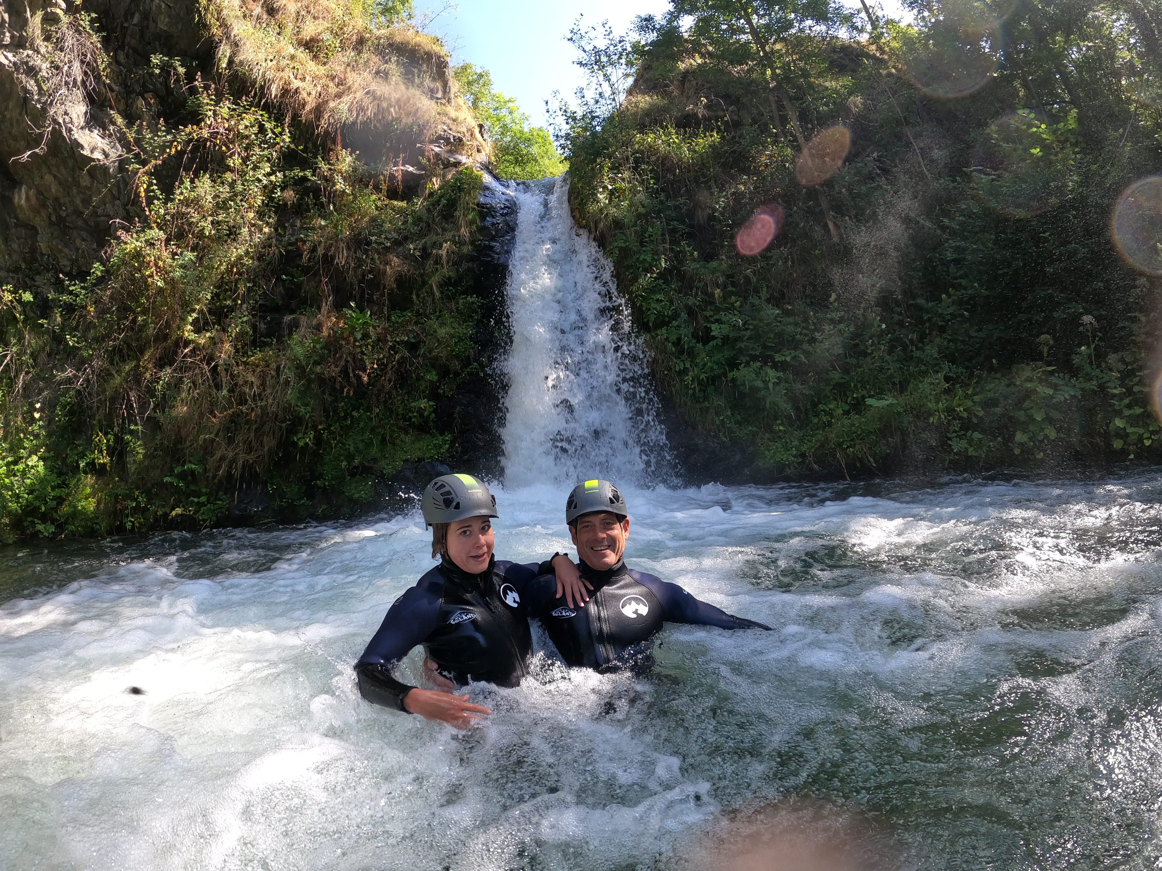 Barranquismo en el Pallars Jussà: dos participantes disfrutando de una poza natural al pie de una cascada durante una ruta de barranquismo en el Prepirineo de Lleida.