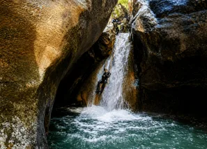 Barrancos del Pallars Jussà: descenso en rápel por una cascada entre estrechas paredes de roca durante una ruta de barranquismo en el Prepirineo de Lleida.