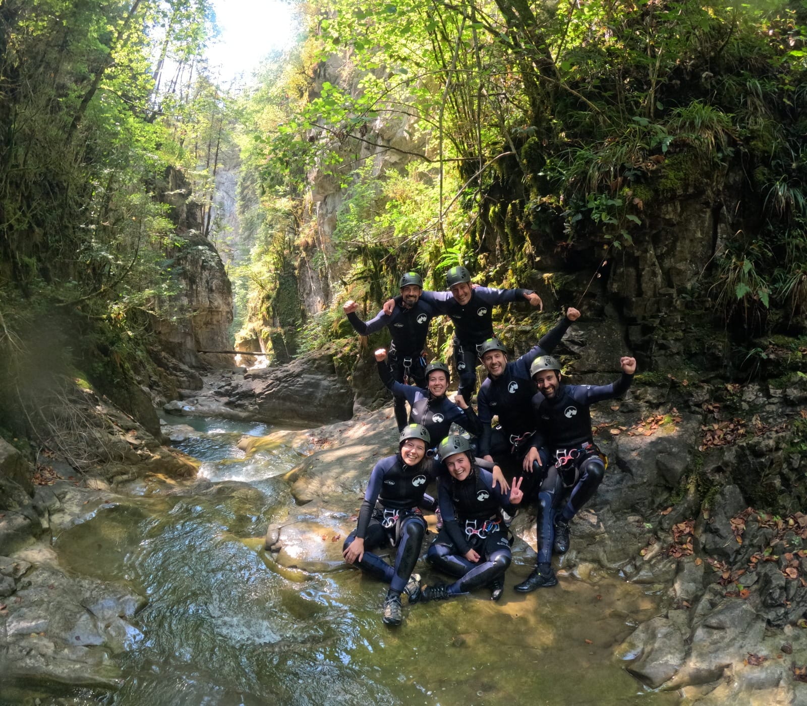 Grupo de participantes de barranquismo posando juntos en el frondoso Barranco de Barbaruens
