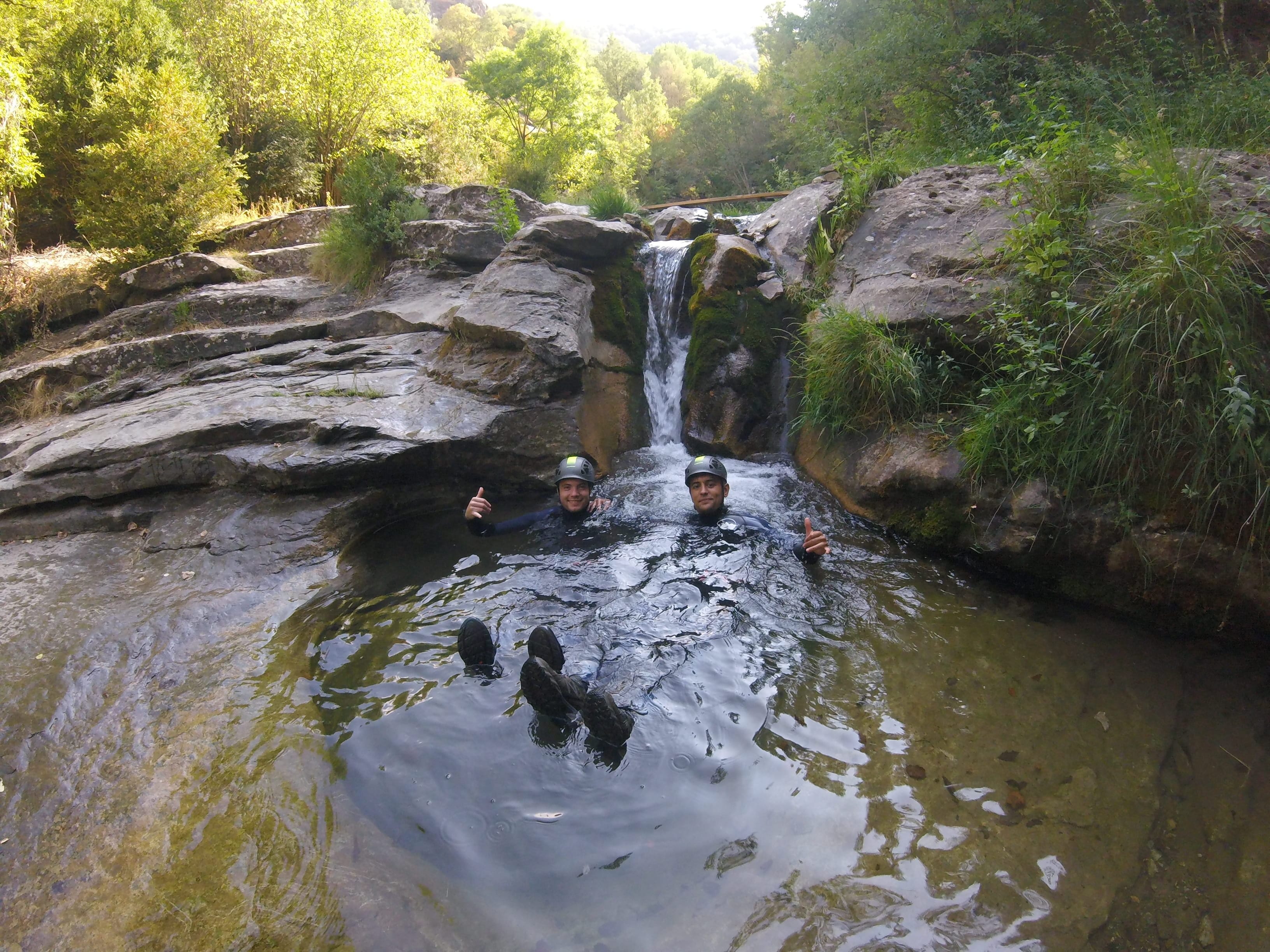 Two participants posing together in a forested section of Les Espones canyon