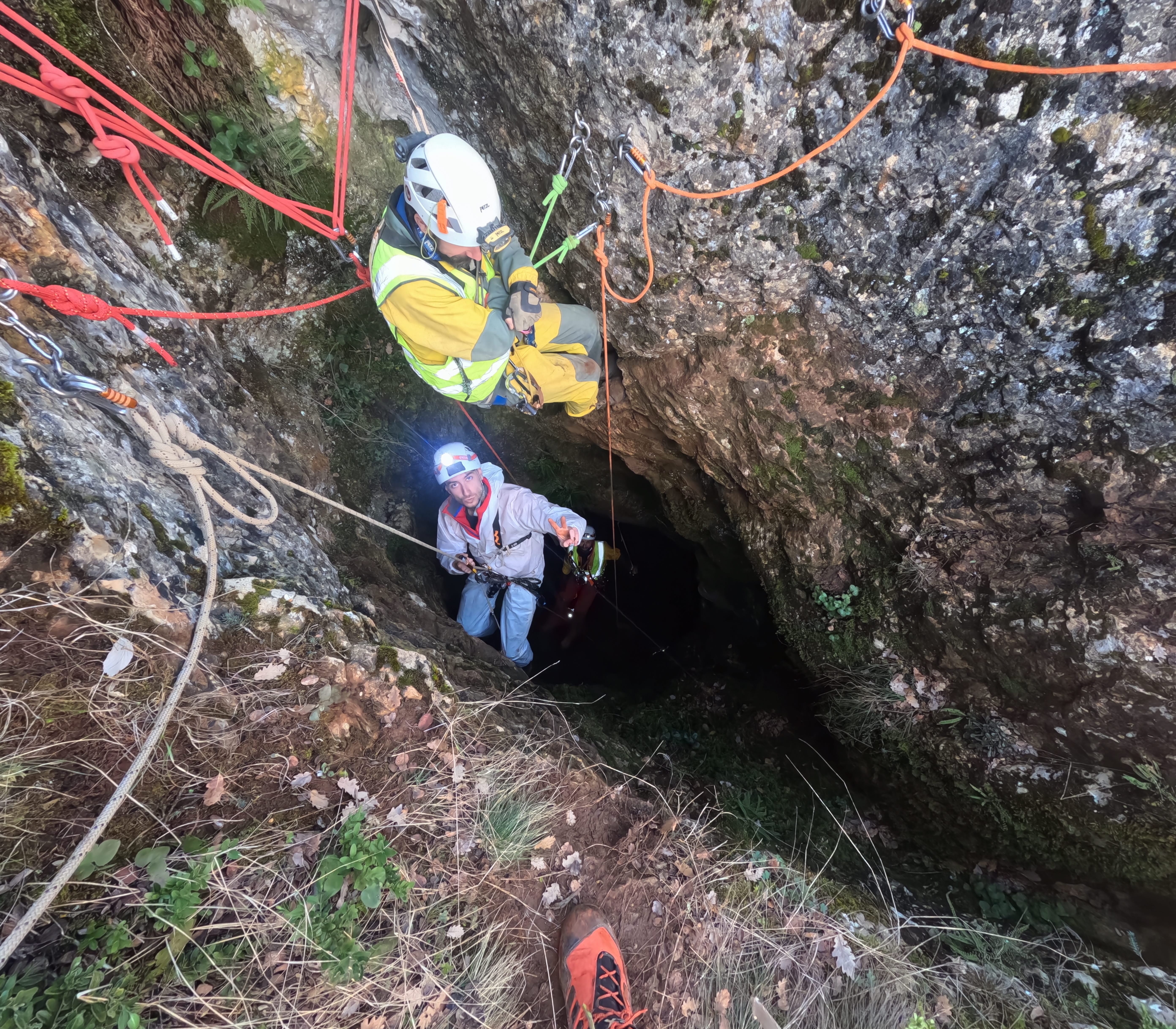 Espeleólogos ascendiendo con cuerdas en la entrada de la Sima Forat dels Diners durante una expedición de espeleología