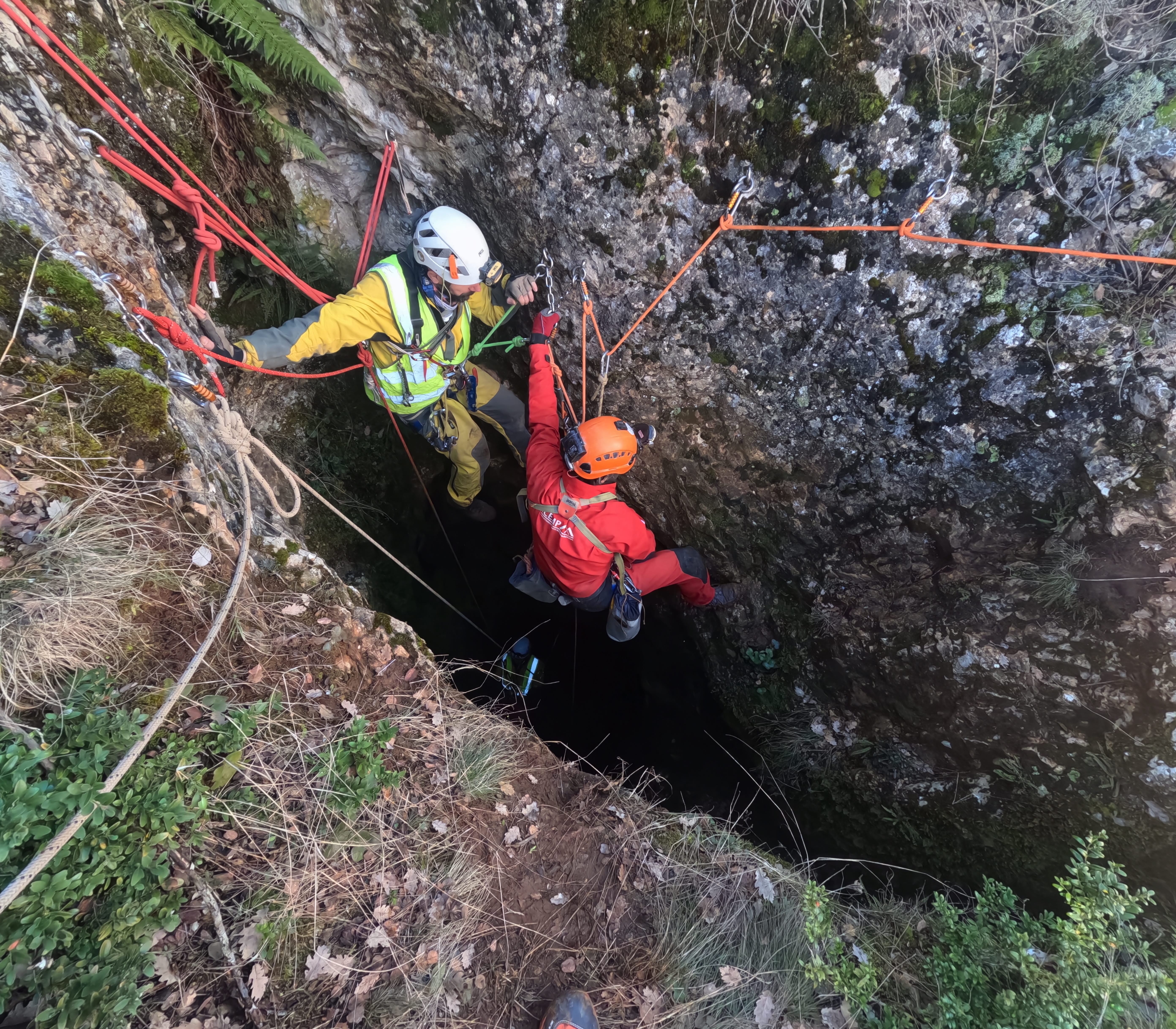 Espeleólogos utilizando técnicas de cuerda en la entrada de la Sima Forat dels Diners durante una expedición de espeleología