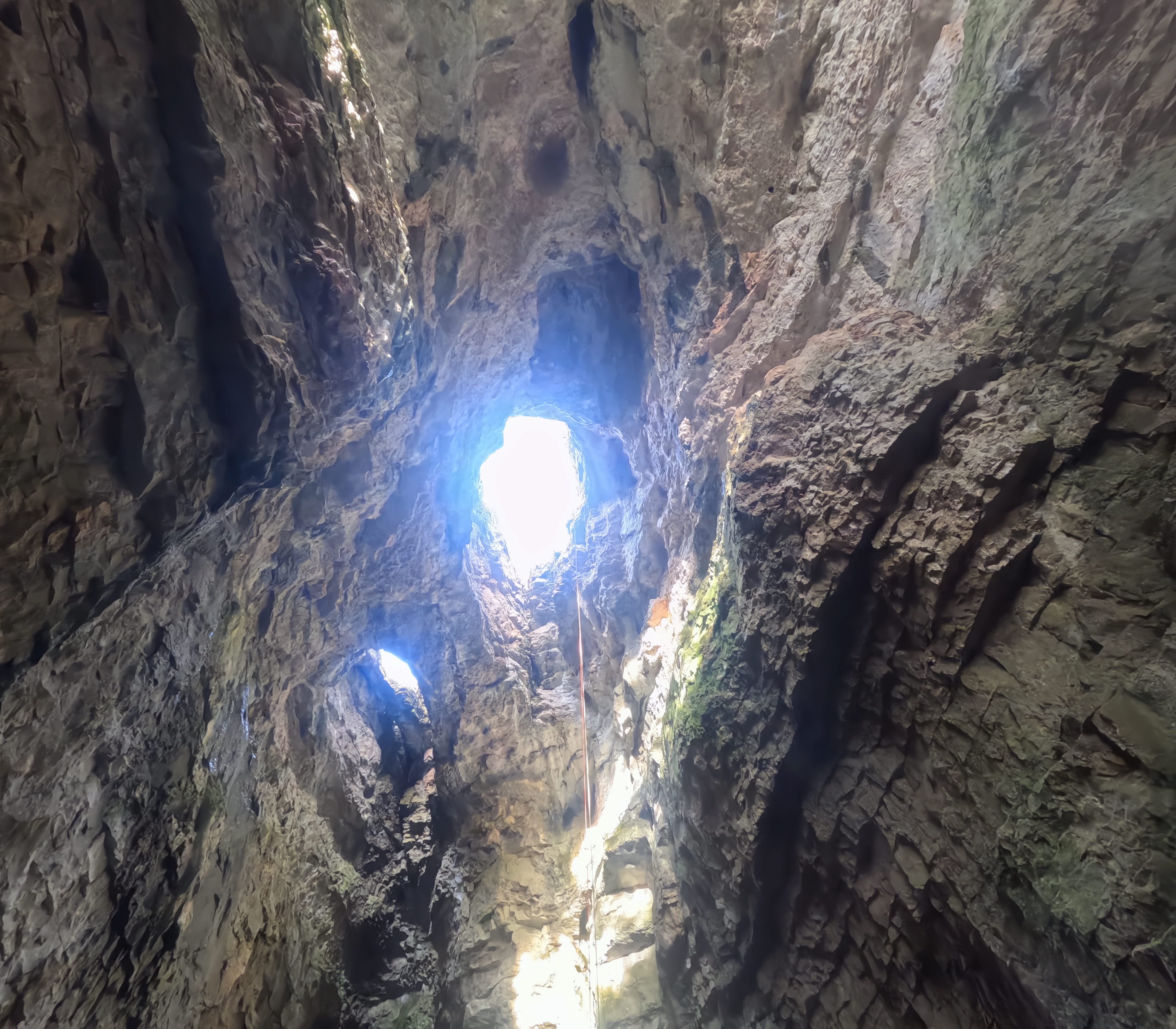 Vista desde el interior del impresionante pozo vertical de la Sima Forat dels Diners, con luz natural entrando por las aberturas de la parte superior