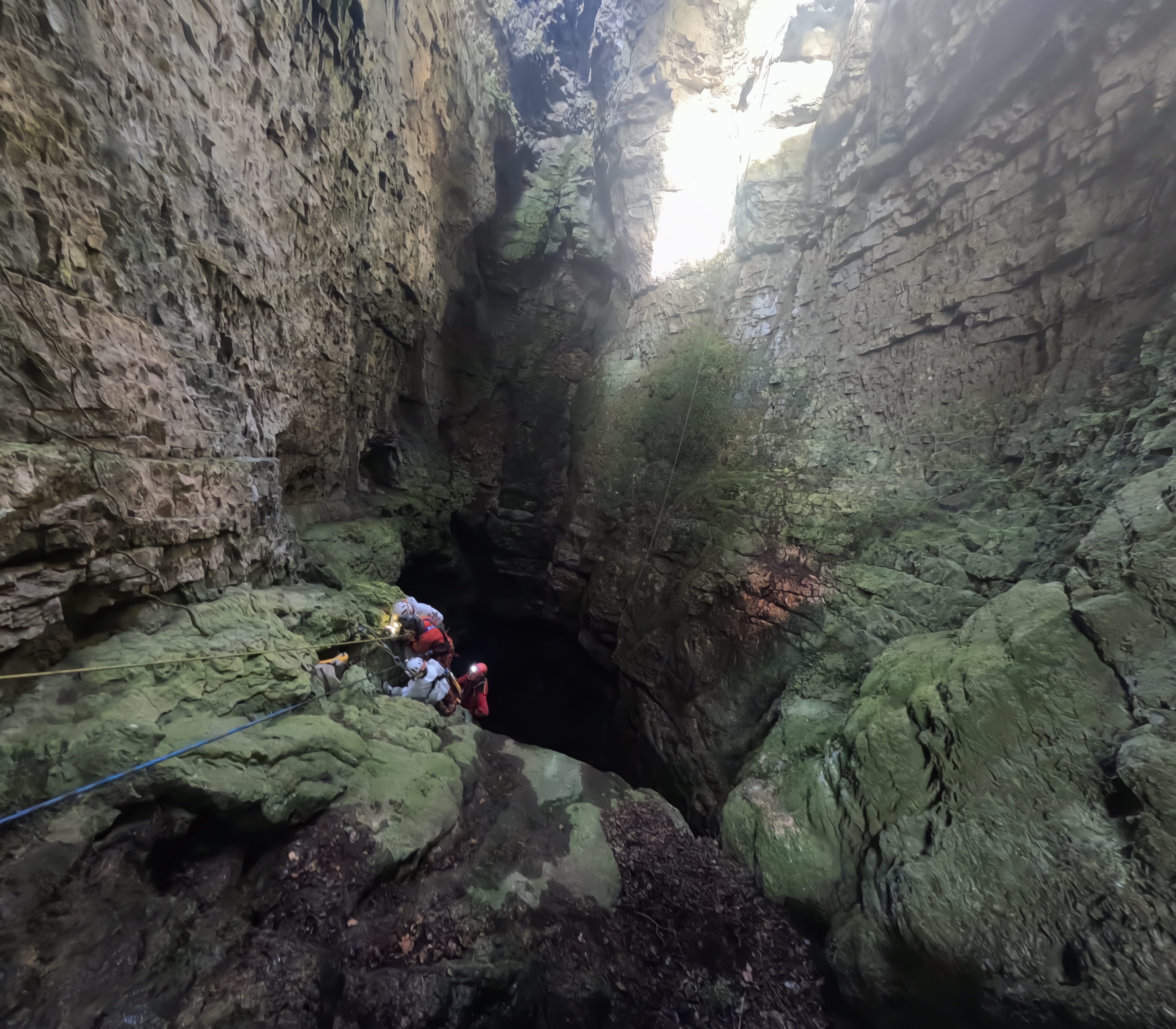 Espeleólogos preparándose para el descenso con cuerda por el profundo pozo vertical de la Sima Forat dels Diners