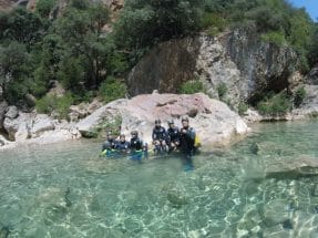 Group of canyoners in the crystal-clear waters of Peonera Canyon