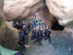Group canyoning through a rocky water passage in Peonera Canyon