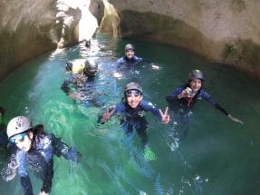 Group of canyoners swimming in a turquoise pool in Peonera Canyon