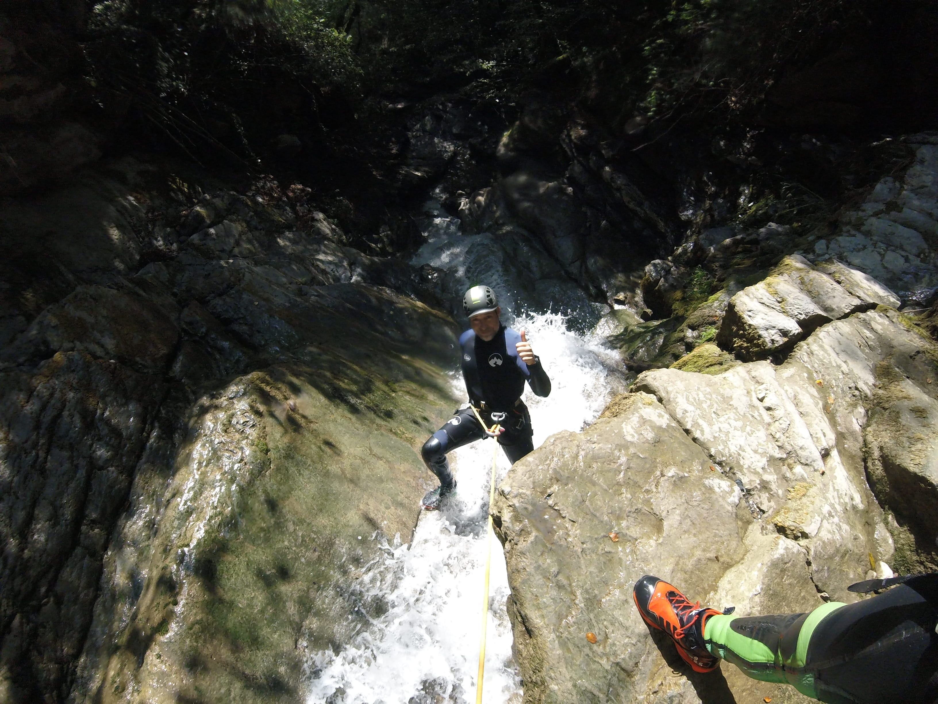 Participant de barranquisme baixant en ràpel per una petita cascada al bosc del Barranc del Pamano