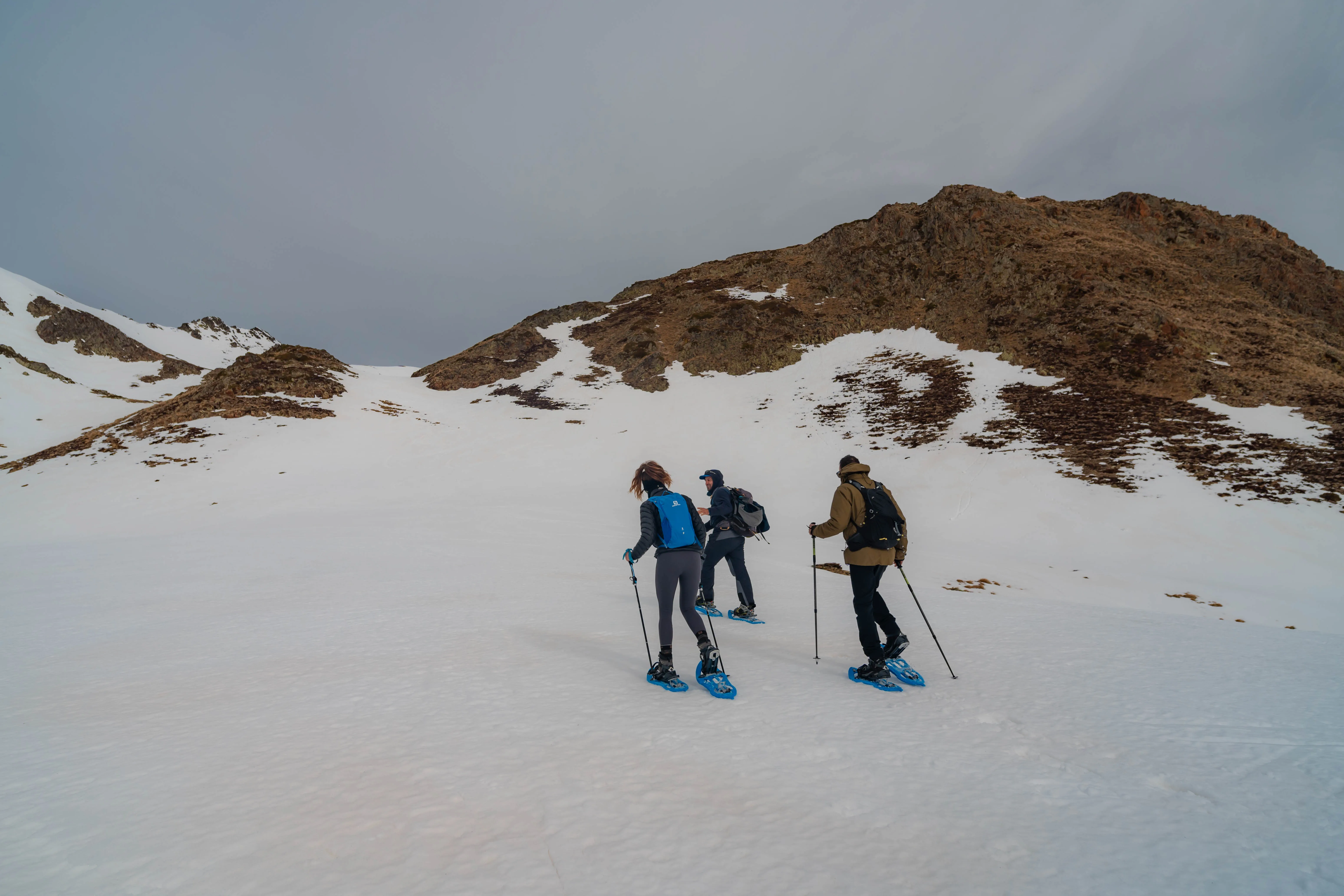 Grupo de excursionistas con raquetas atravesando una cuenca de montaña nevada durante la ruta al Pic de la Coma del Forn