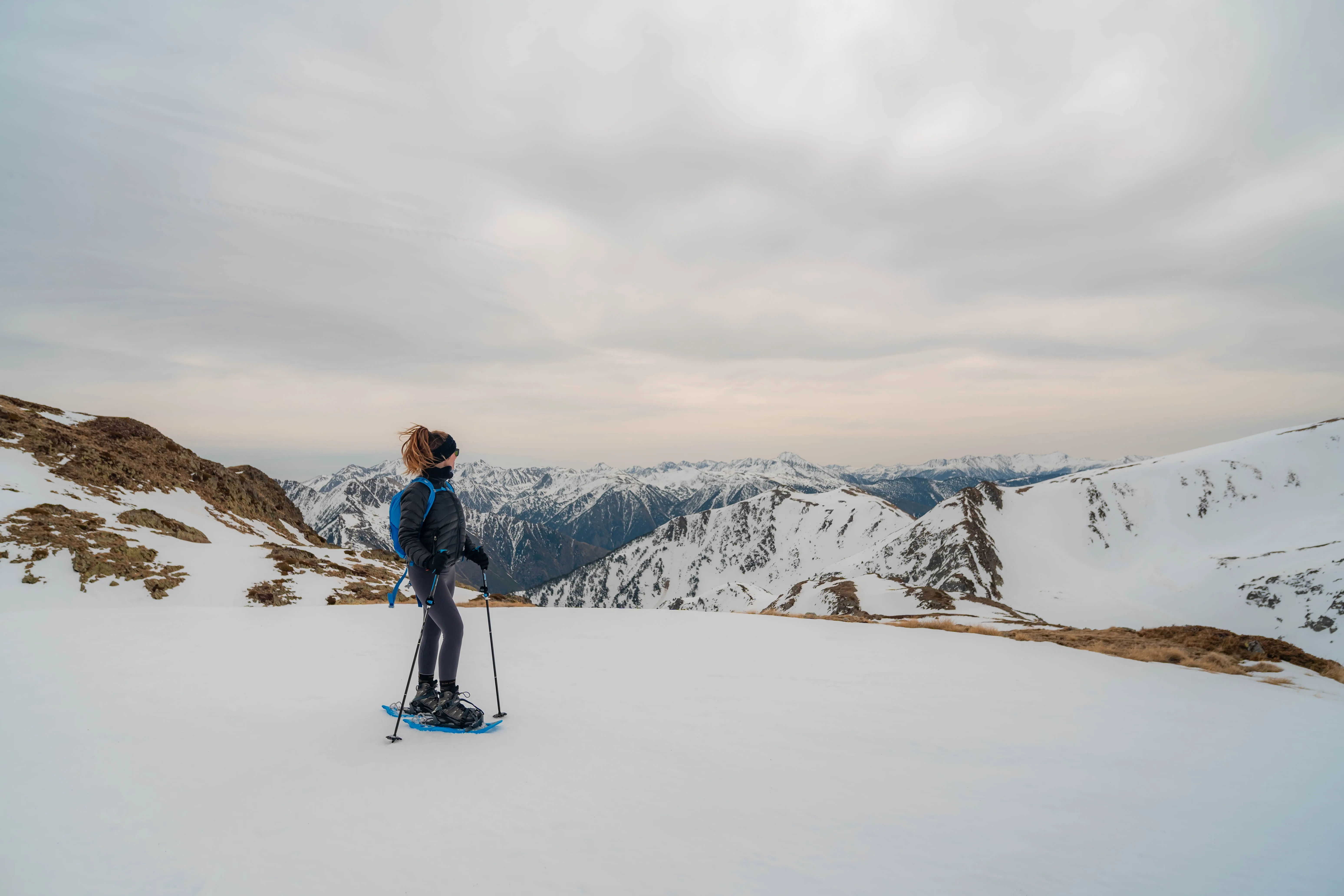 Excursionista con raquetas contemplando las montañas nevadas de los Pirineos durante el ascenso al Pic de la Coma del Forn