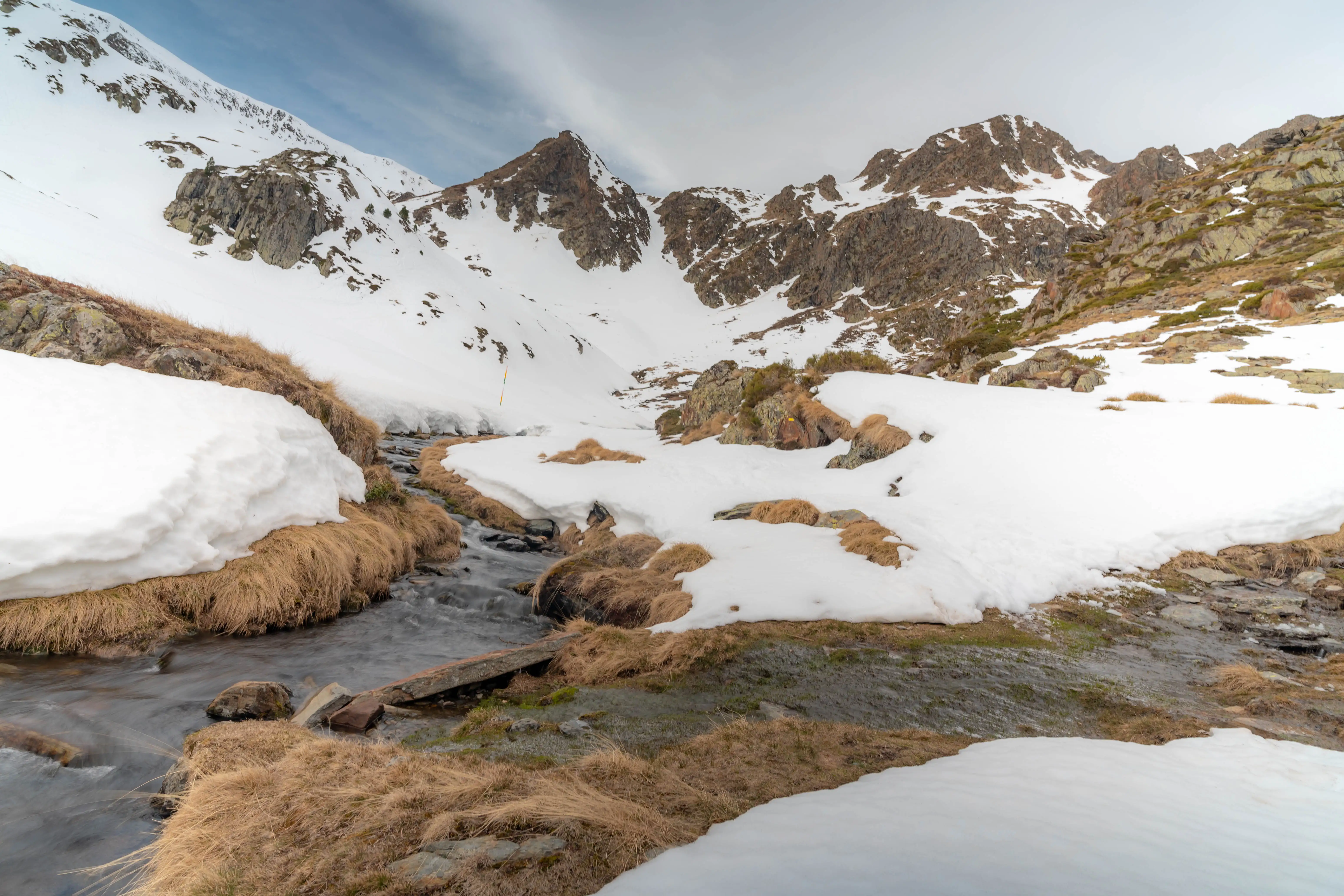 Arroyo de montaña entre laderas cubiertas de nieve durante la ruta al Pic de la Coma del Forn