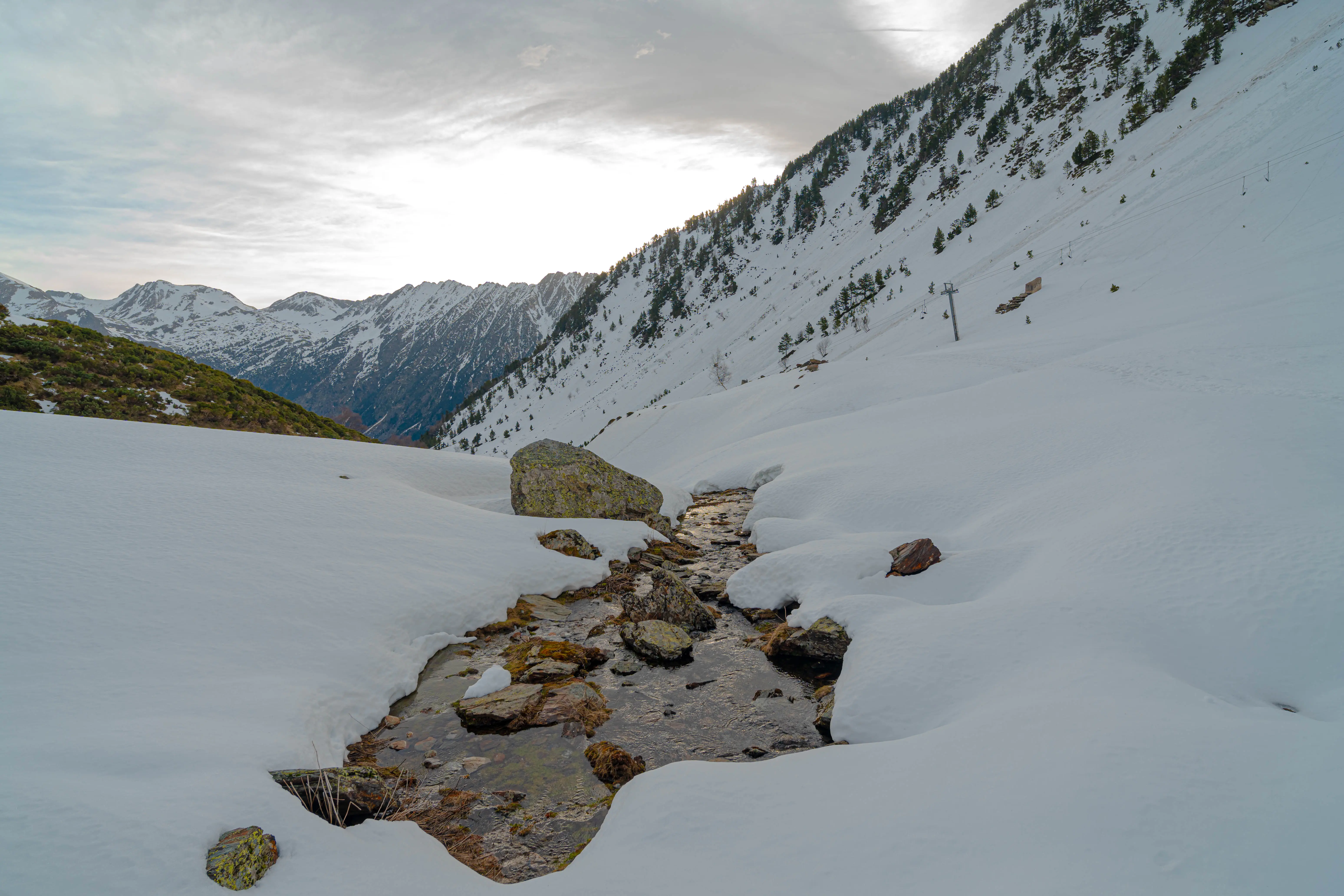 Arroyo de montaña entre la nieve durante la ruta con raquetas al Pic de la Coma del Forn