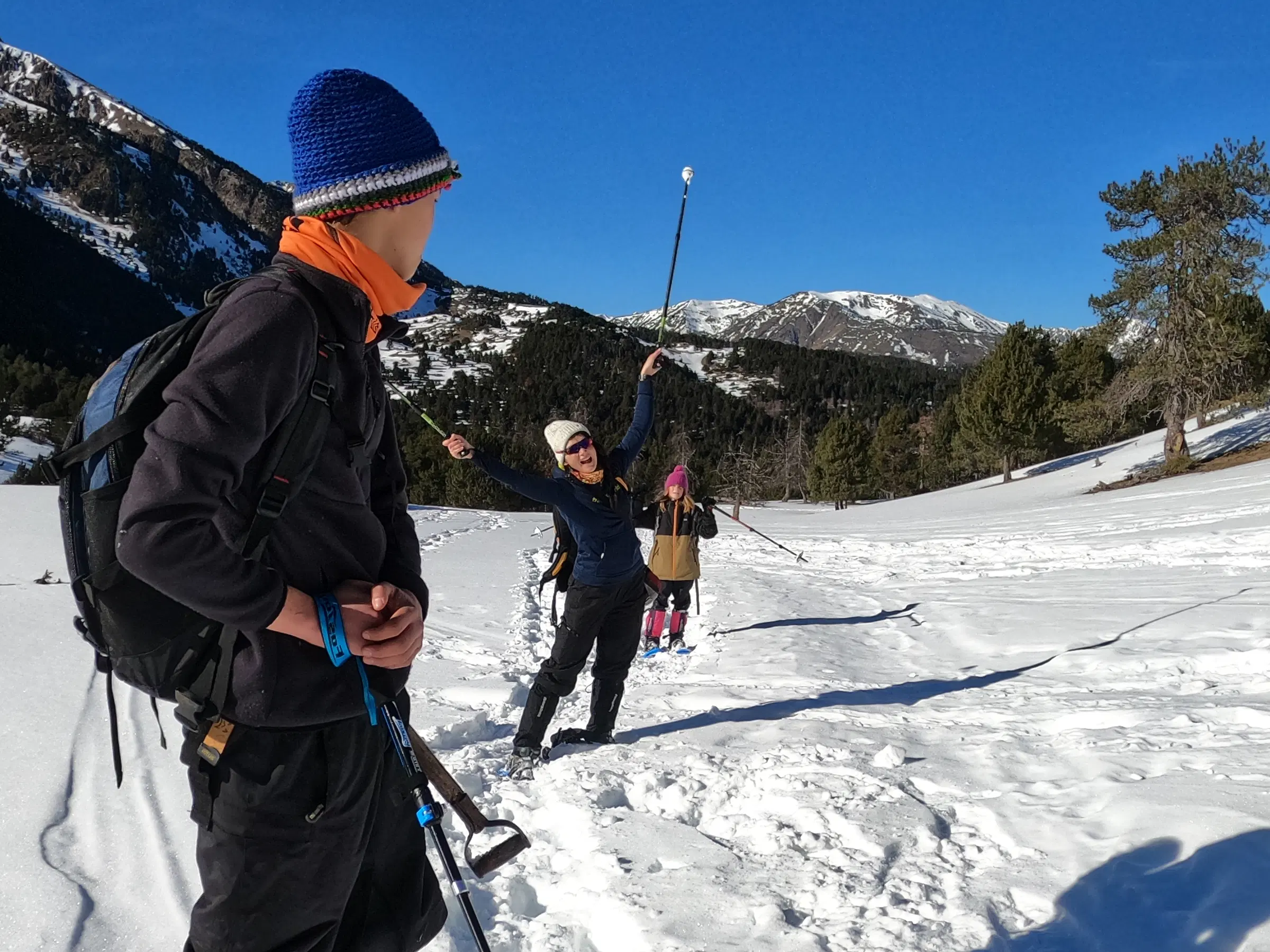 Grupo disfrutando de una ruta con raquetas de nieve en un día soleado, con vistas a las montañas, camino del Refugi Pla de la Font, en los Pirineos catalanes
