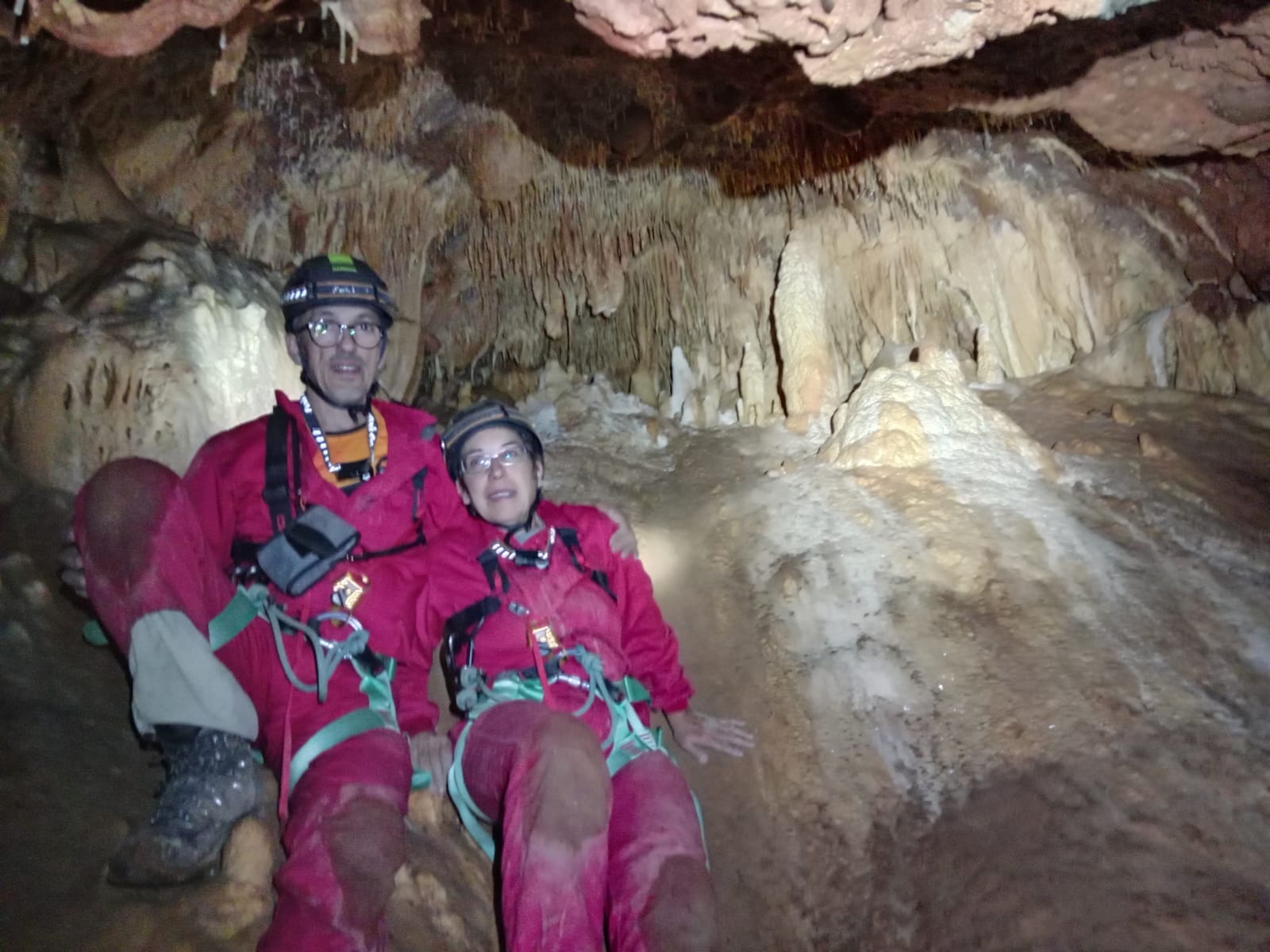 Dos espeleòlegs amb casc i equip tècnic descansant entre estalactites i formacions calcàries a l’interior de la Sima del Barbuxell