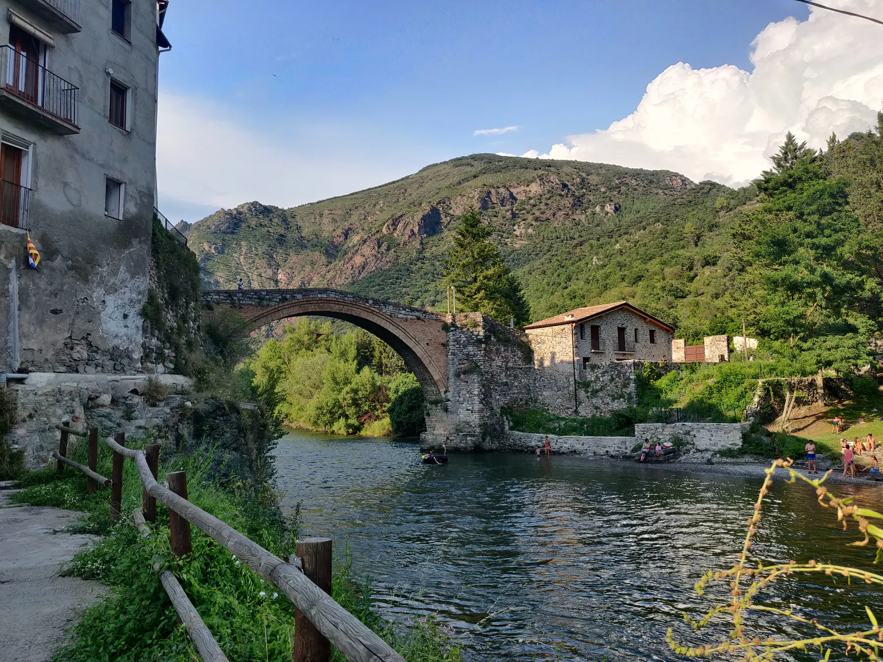 Qué hacer en La Pobla de Segur: visitar el puente medieval de Gerri de la Sal sobre el río Noguera Pallaresa, rodeado de montañas.