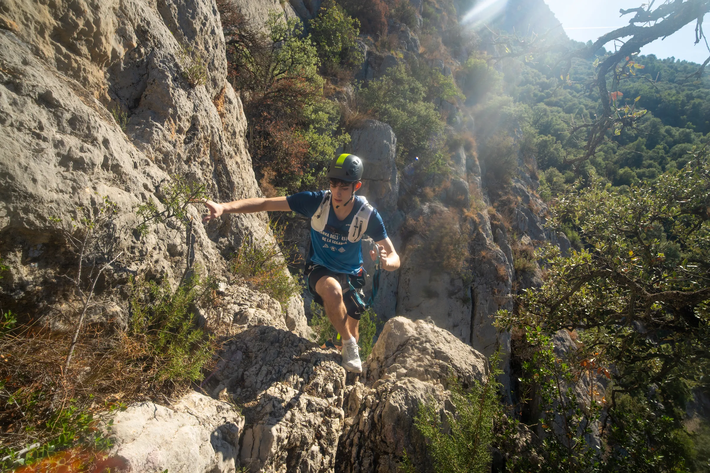 Deportista ascendiendo por un tramo rocoso de la vía ferrata Olmo Soler