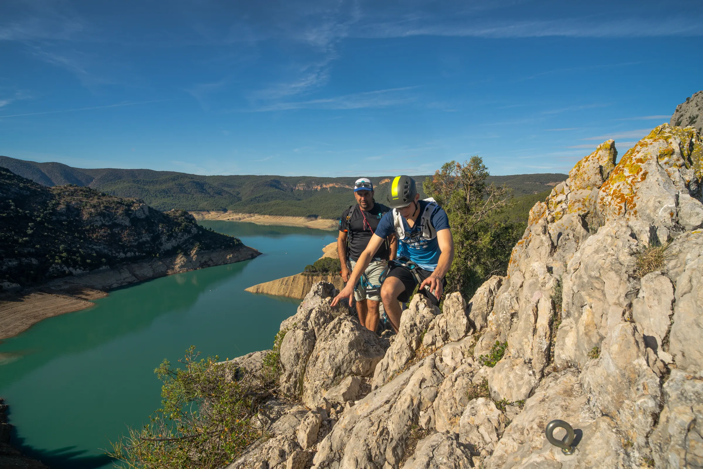 Dos escaladores avanzando por la cresta de la vía ferrata Olmo Soler junto al embalse