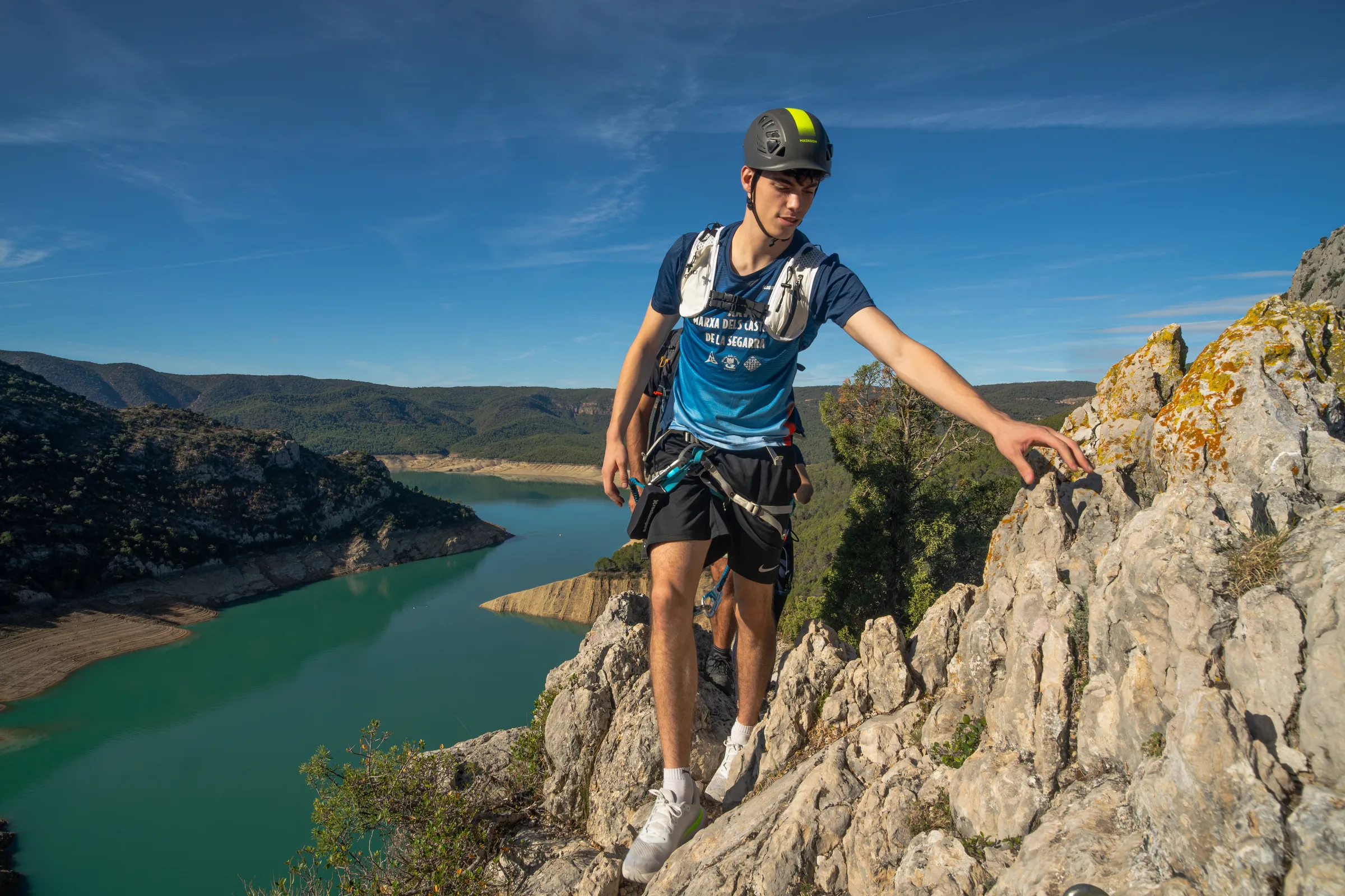 Hombre recorriendo un tramo de roca de la vía ferrata Olmo Soler con vistas panorámicas
