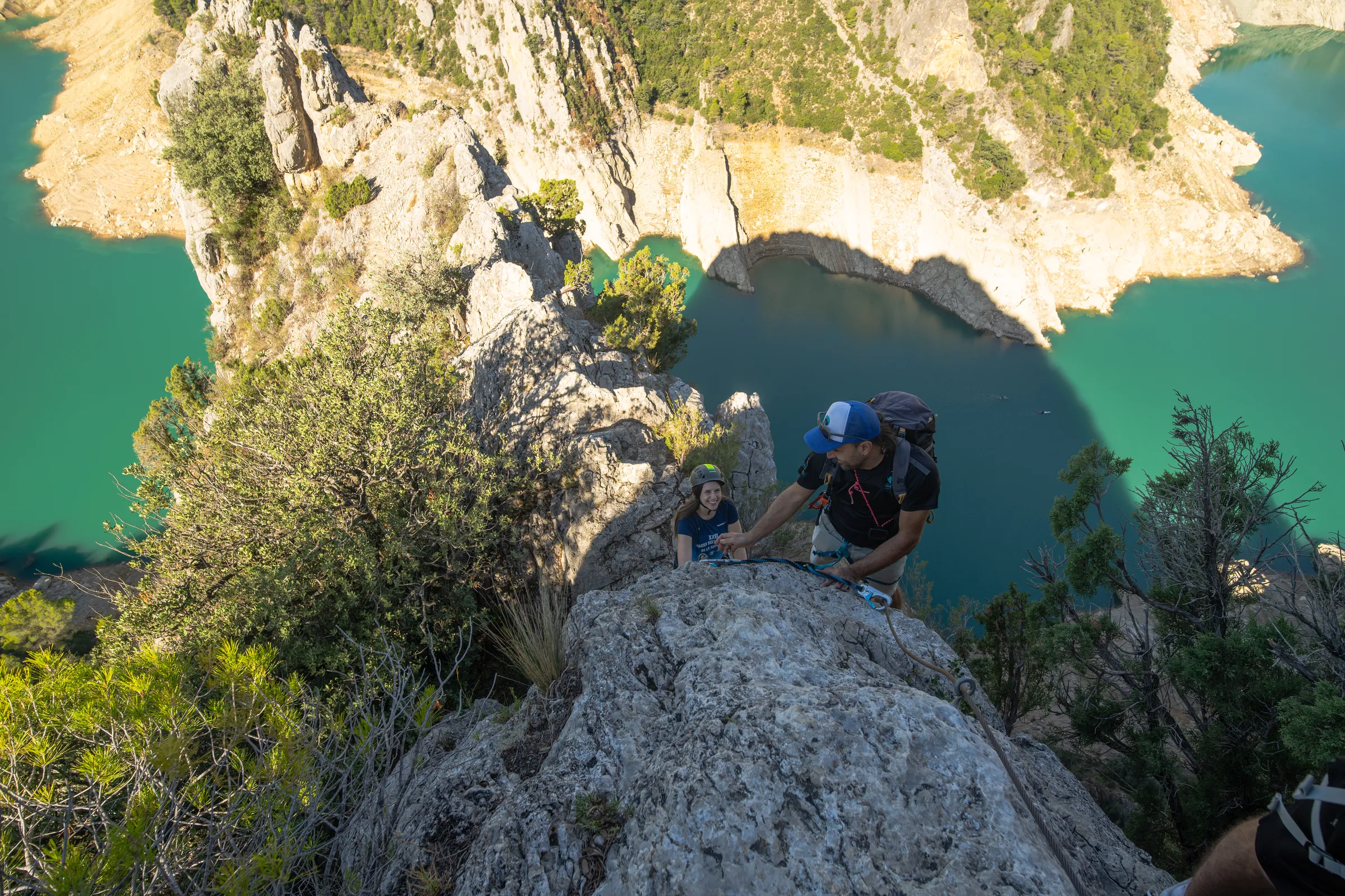 Ascensión por un tramo vertical de la vía ferrata Olmo Soler con vistas al agua