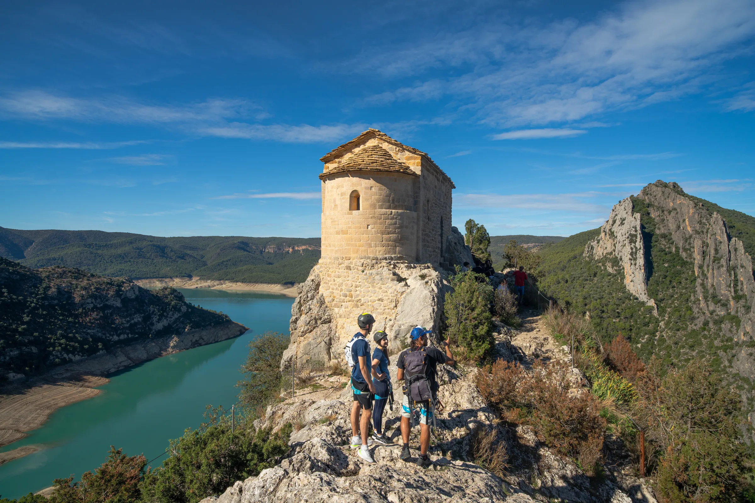Ermita de la Mare de Déu de la Pertusa y excursionistas al finalizar la vía ferrata Olmo Soler