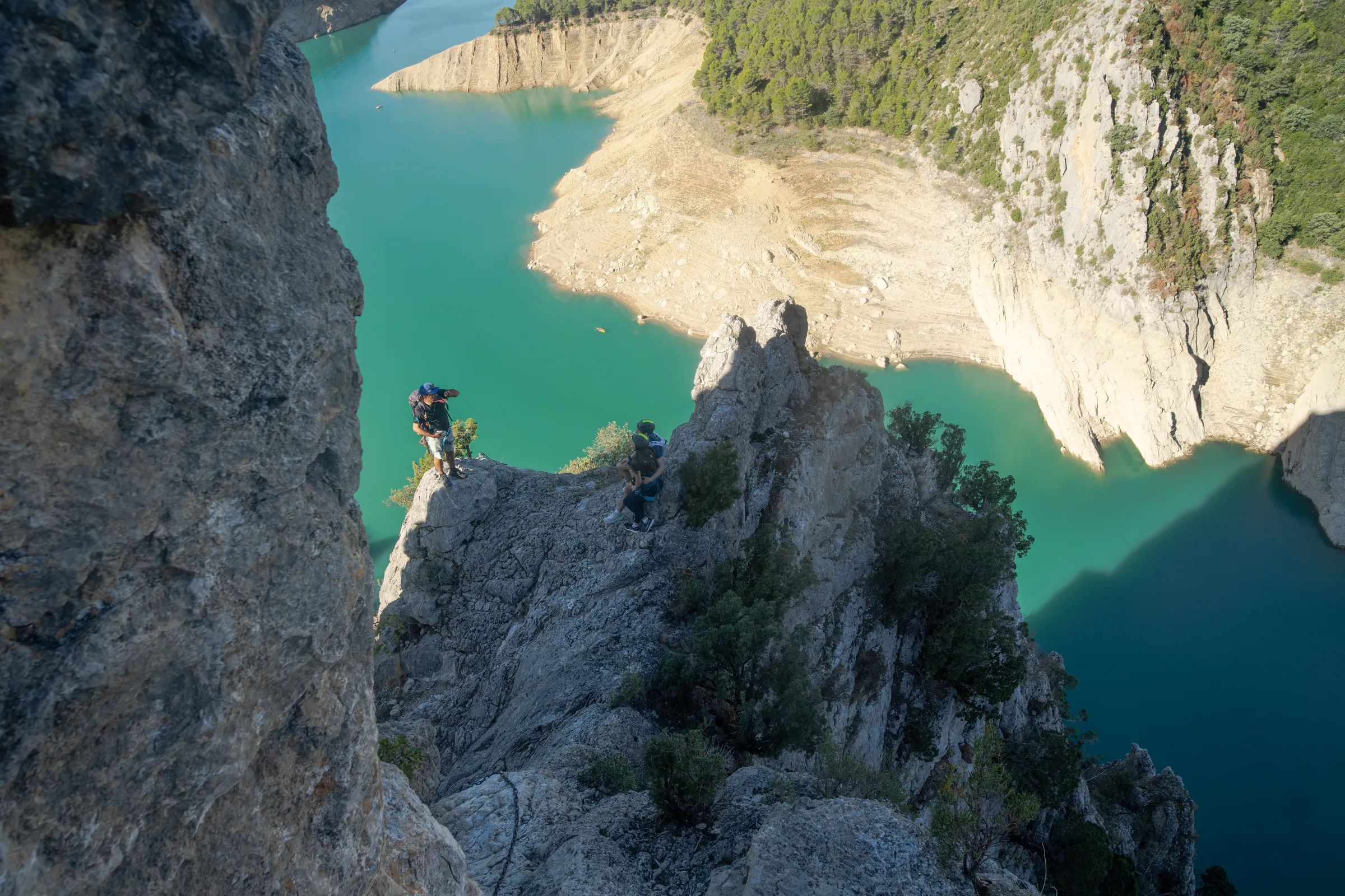 Vista aérea de escaladores en la vía ferrata Olmo Soler sobre las aguas turquesas